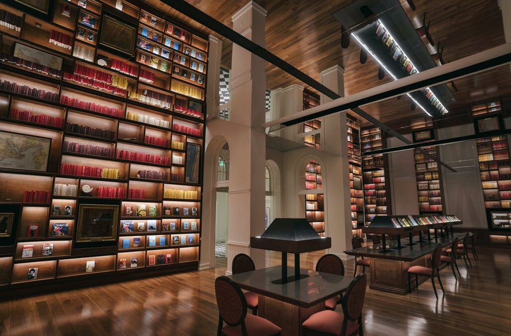 Glassless Mirror ceiling installation at the Planet Word Museum library, featuring a reflective overhead surface that creates crisp, distortion-free reflections of the bookshelves and reading area below.